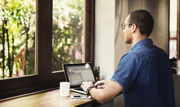 Jovem homem bonito usando laptop — Fotografia de Stock