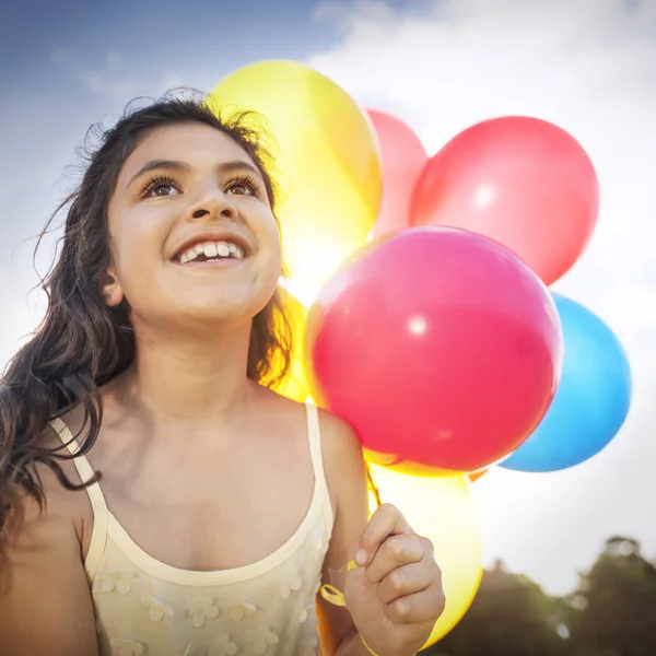 Mädchen spielt mit bunten Luftballons — Stockfoto