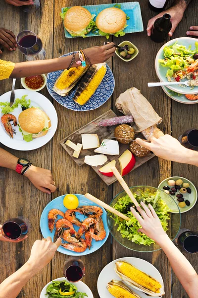 Amigos comendo para grande mesa — Fotografia de Stock