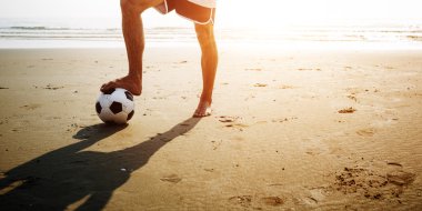 Kumsalda futbol oynayan adam