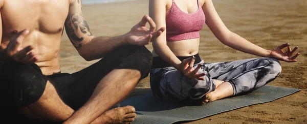 Koppel doen yoga op het strand — Stockfoto
