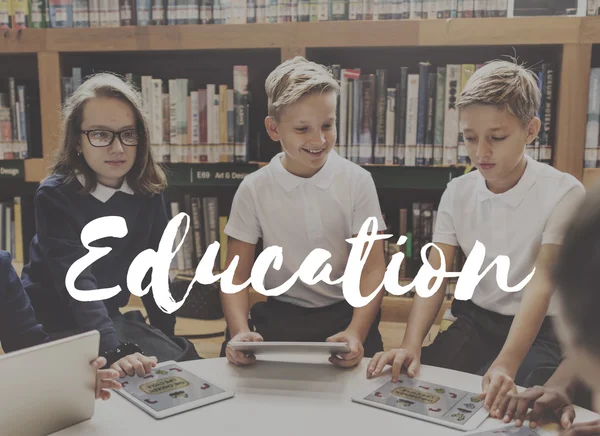 Enfants avec appareils numériques dans la bibliothèque — Photo