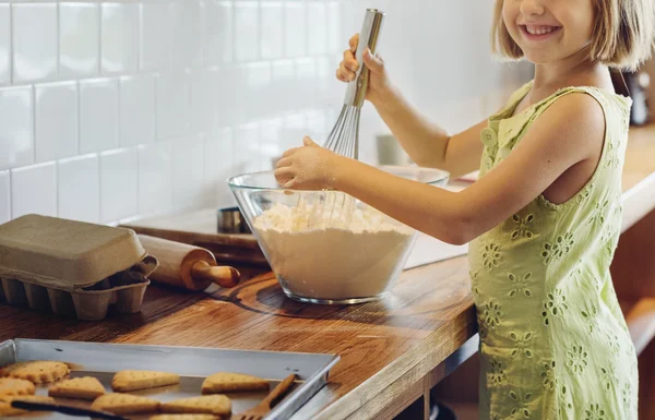 Menina amassando massa de farinha de biscoitos — Fotografia de Stock