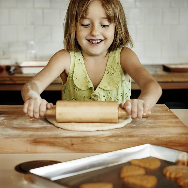 Menina amassando massa de farinha de biscoitos — Fotografia de Stock