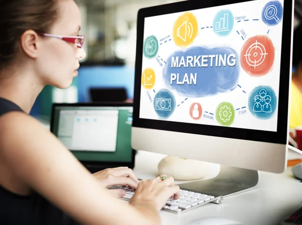 Businesswoman working on computer with marketing plan — Stock Photo, Image