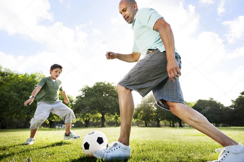 father playing football with little son