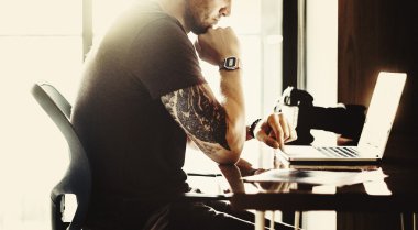 Studio dizüstü bilgisayar ile çalışan fotoğrafçı