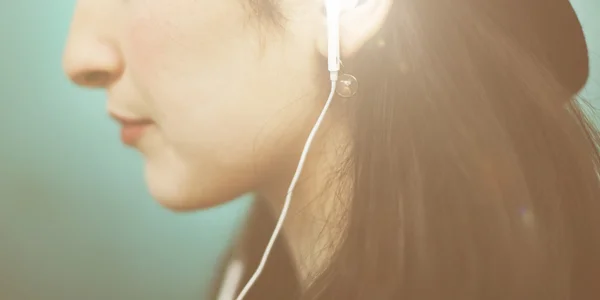 Jong meisje luisteren muziek in oortelefoons — Stockfoto