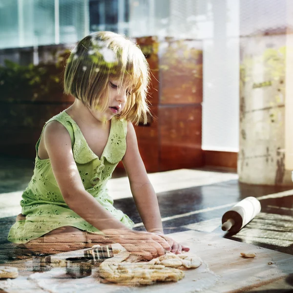 Fille pétrissant la pâte pour les cookies — Photo