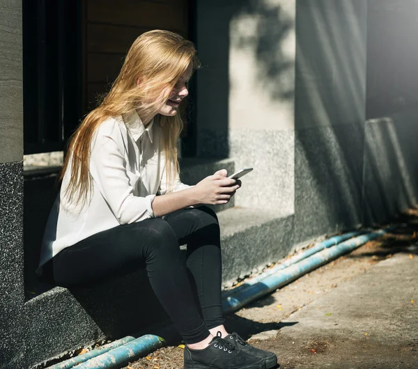 Vrouw op straat met telefoon — Stockfoto