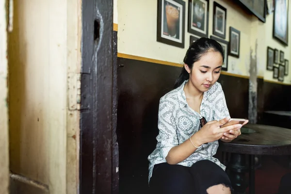 Menina no café olhando para o telefone — Fotografia de Stock