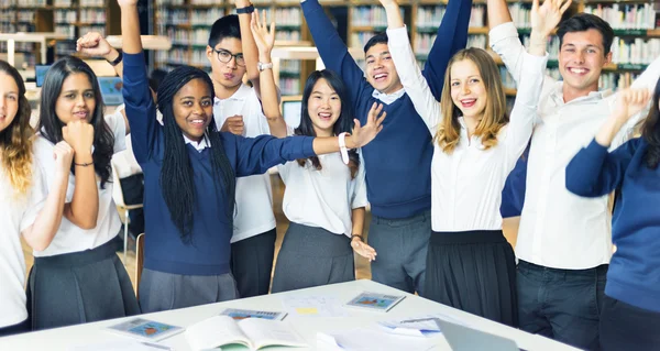 Estudantes felizes na biblioteca universitária — Fotografia de Stock