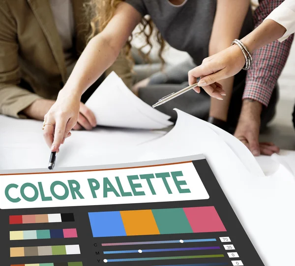 Diseñadores trabajando con póster y paleta de colores — Foto de Stock