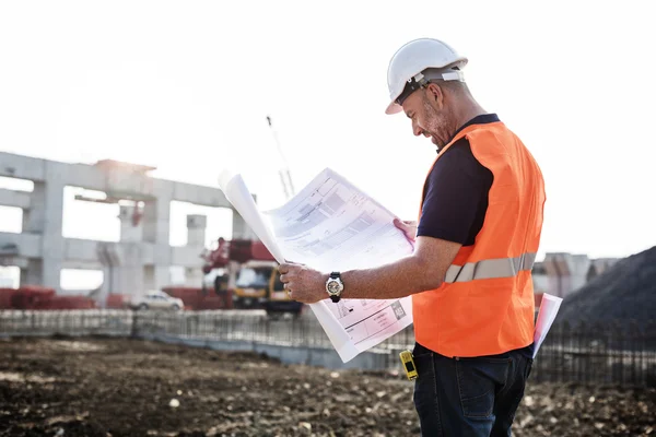 Trabalhador da construção olhando para o plano de negócios — Fotografia de Stock