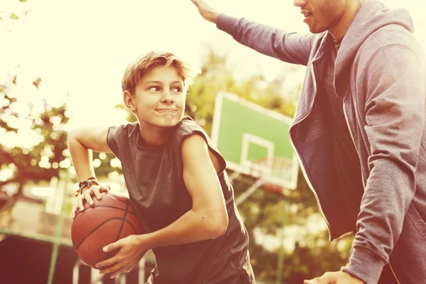 Athletischer Basketballtrainer spielt mit Jungen — Stockfoto