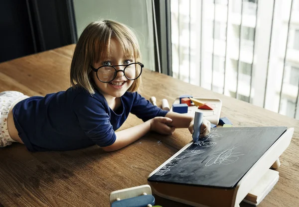 Kind Playing en puttend uit blackboard — Stockfoto