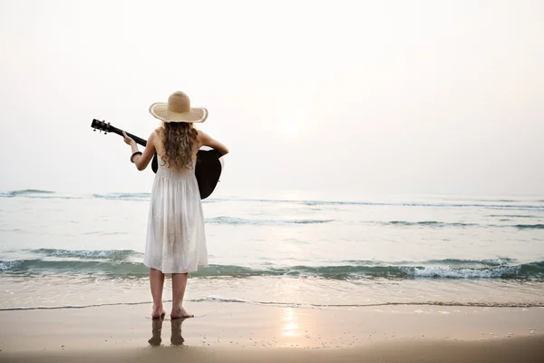 Flicka på stranden med gitarr — Stockfoto