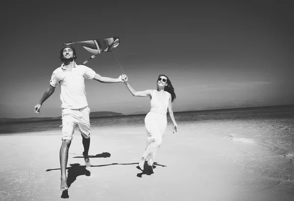 Paar spielt Drachen am Strand — Stockfoto