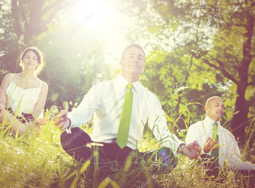 business people meditating outdoors