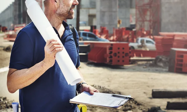 Construction Worker looking at Business Plann — Stock Photo, Image