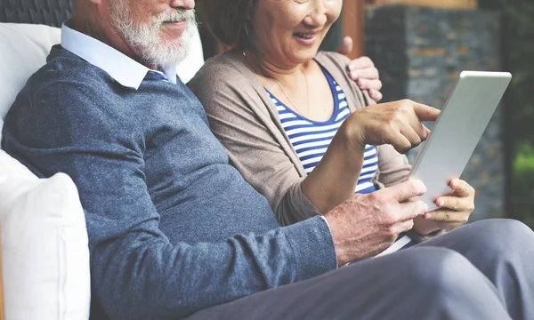 Paar lacht und schaut in Tablette — Stockfoto