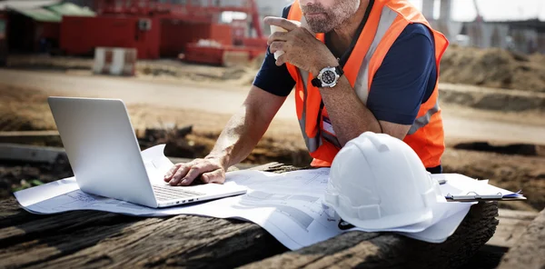 Trabalhador da construção olhando para o plano de negócios — Fotografia de Stock