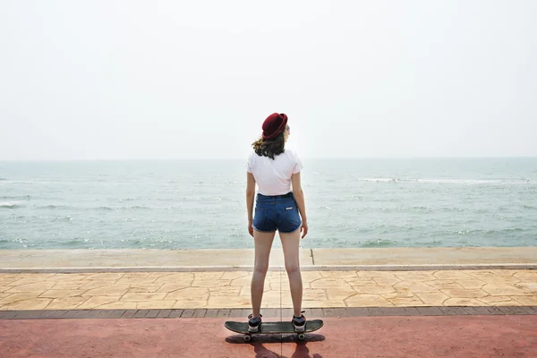 Mädchen fährt auf Skateboard in Meeresnähe — Stockfoto