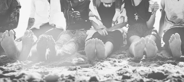 Freunde sitzen auf Sand am Strand — Stockfoto