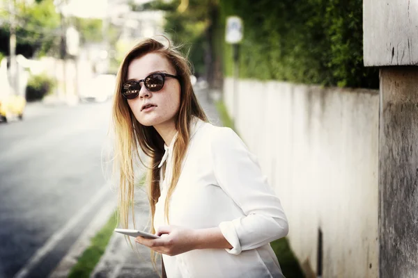 Vrouw op straat met telefoon — Stockfoto