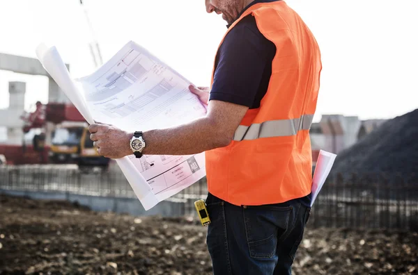 Trabajador de la construcción mirando a Business Plann —  Fotos de Stock