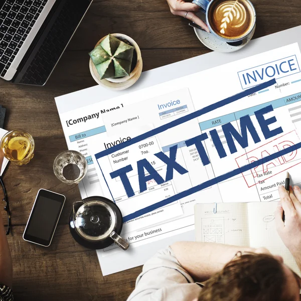 Mesa con cartel con Impuestos tiempo — Foto de Stock