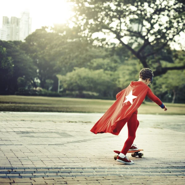 Superhero Kid montando no skate — Fotografia de Stock