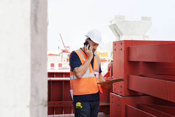 Construcción Trabajador examina dibujos — Foto de Stock