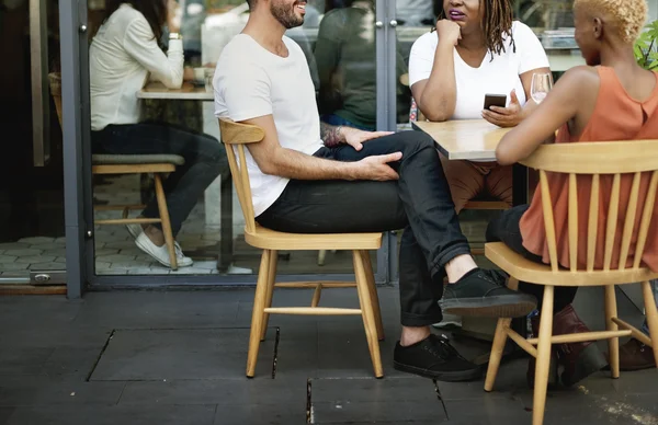 Gente sentada a la mesa en la calle — Foto de Stock