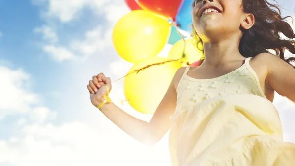 Mädchen spielt mit bunten Luftballons — Stockfoto