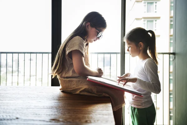 Hermanas leyendo un libro juntas —  Fotos de Stock