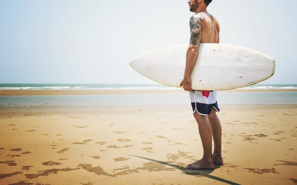 Mężczyzna na plaży z deska — Zdjęcie stockowe