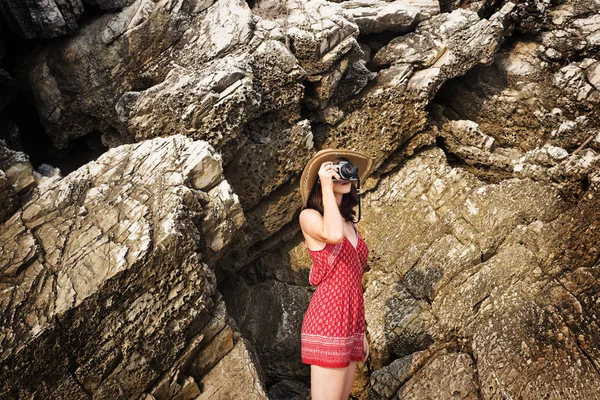 Chica con cámara cerca de roca — Foto de Stock