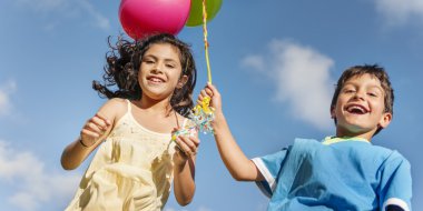 Çocuklar renkli balonlarla oynuyorlar.