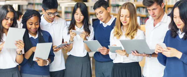 Estudiantes navegando gadgets digitales —  Fotos de Stock