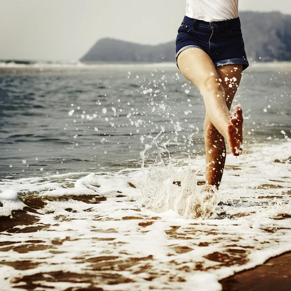 Vrouw die op het strand loopt — Stockfoto