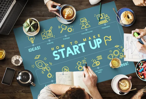 Table with poster with start up — Stock Photo, Image