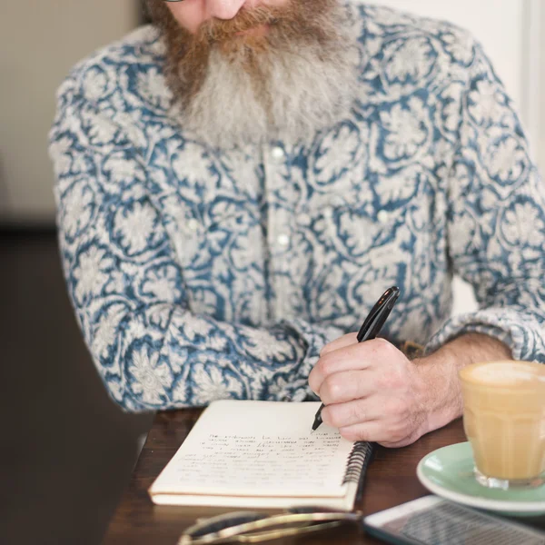 Homme avec barbe écriture notes — Photo