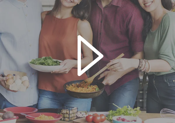 Amigos com comida na cozinha — Fotografia de Stock