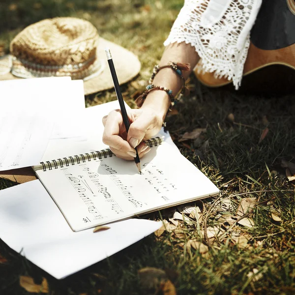 Девушка, пишущая песню в парке — стоковое фото