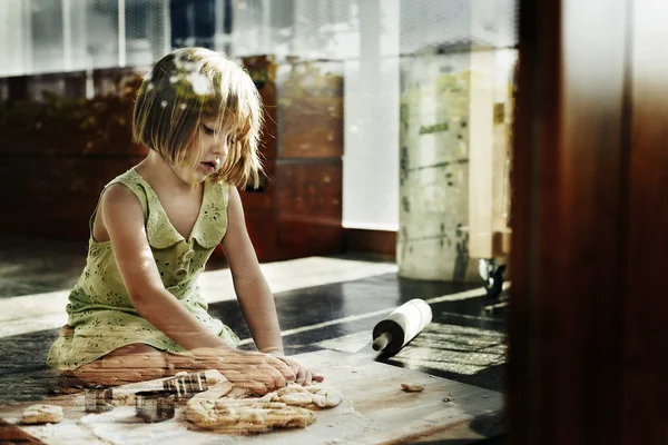 Fille pétrissant la pâte pour les cookies — Photo