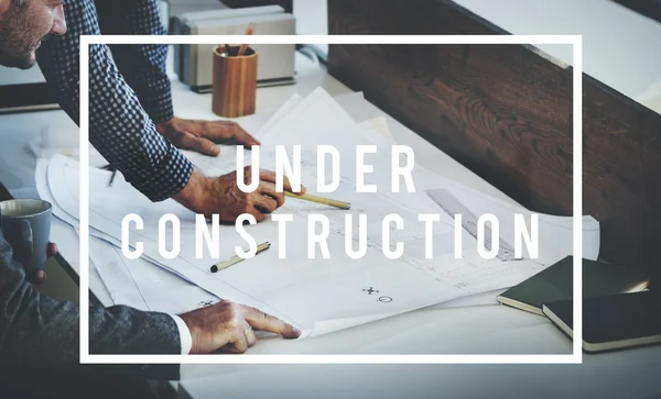 Colleagues discussing and Under Construction — Stock Photo, Image