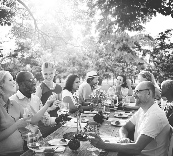 Personas sentadas a la mesa y celebrando — Foto de Stock