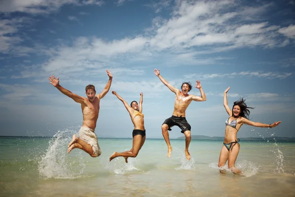 Vänner njuter på stranden — Stockfoto