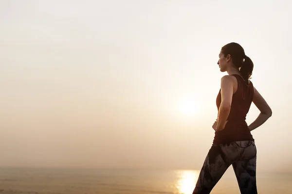 Kvinna stående på stranden — Stockfoto